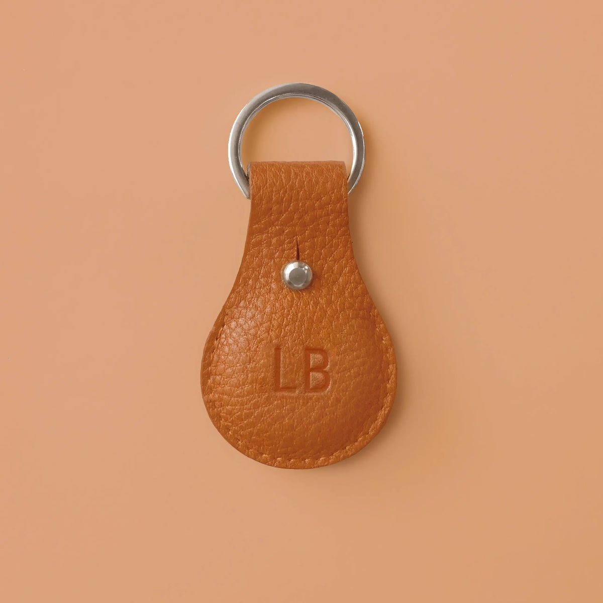 Airtaghülle aus orangefarbenem Leder mit Schlüsselring und eingeprägten Initialen