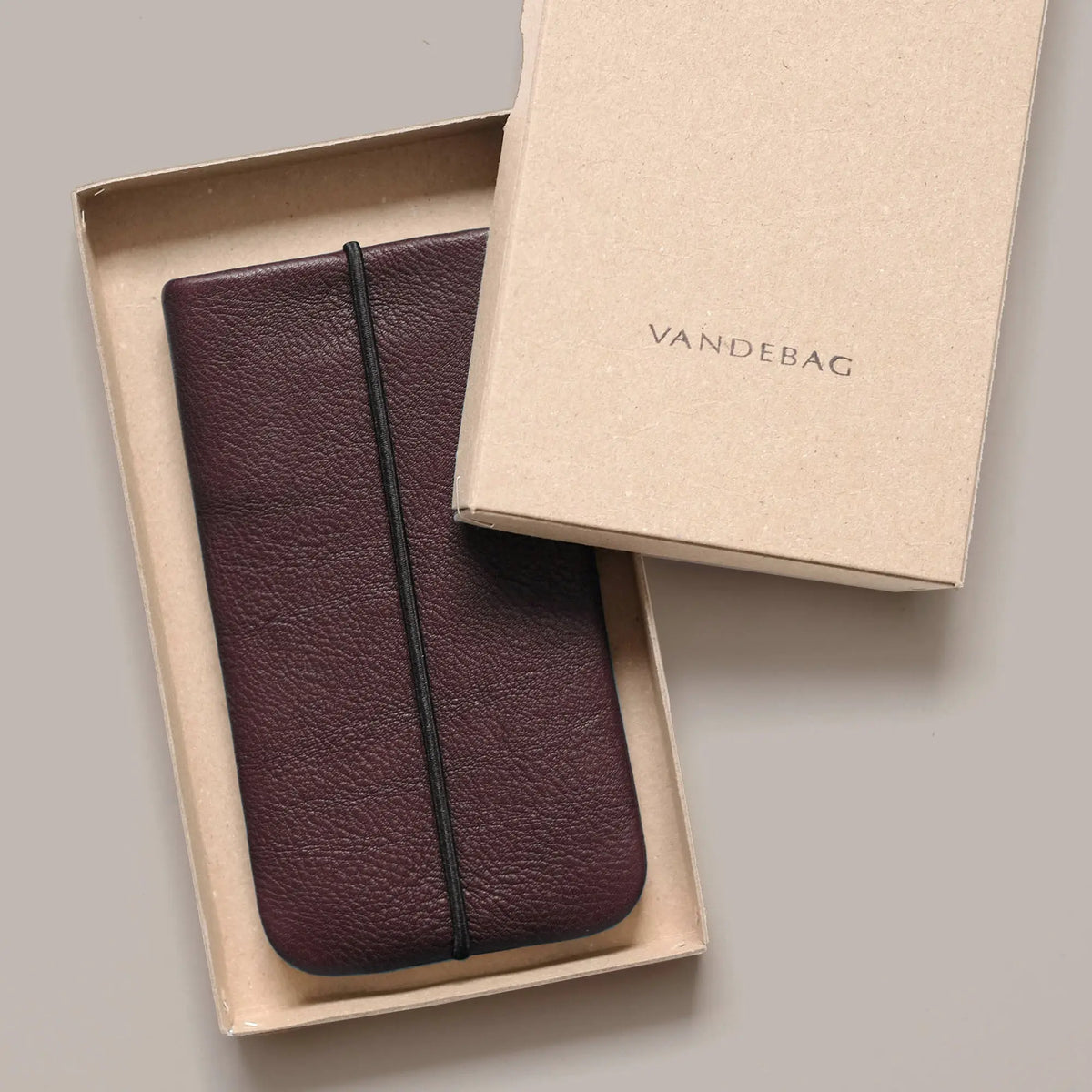 Handyhülle aus schokobraunem Leder liegt in einer Geschenkbox