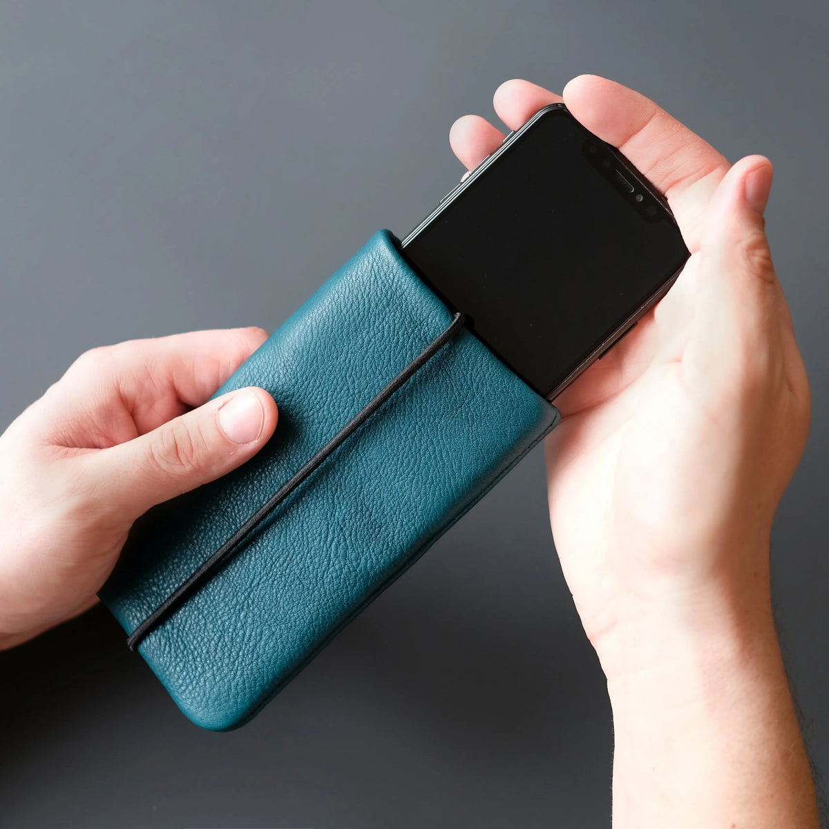 ein Smartphone  wir in eine iPadhülle aus Leder geschoben