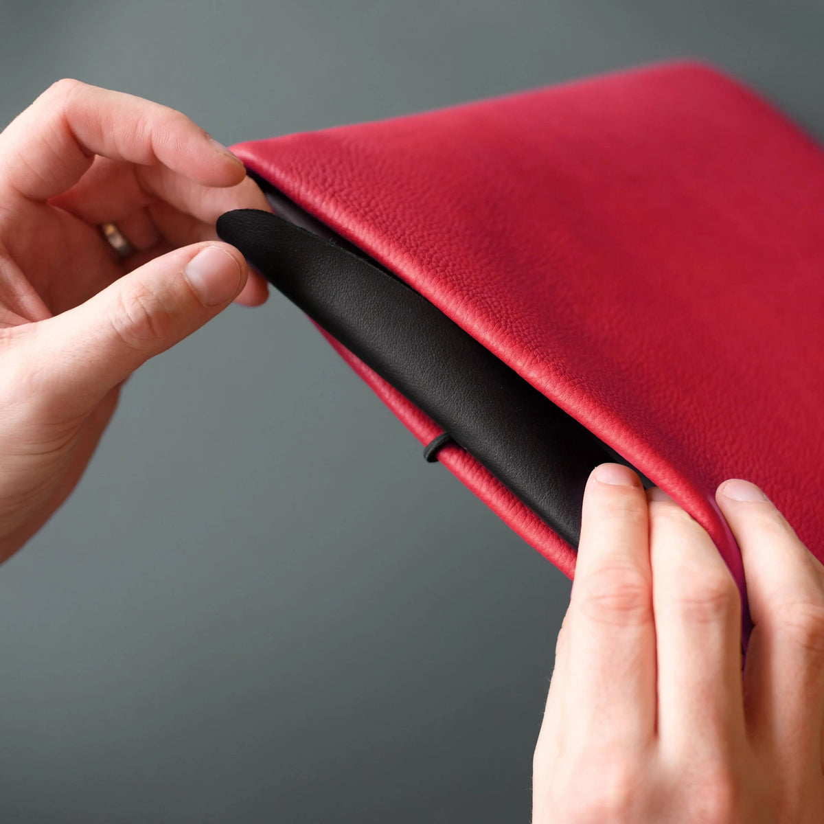 rote Macbookhülle wird mit schwarzer Klappe verschlossen
